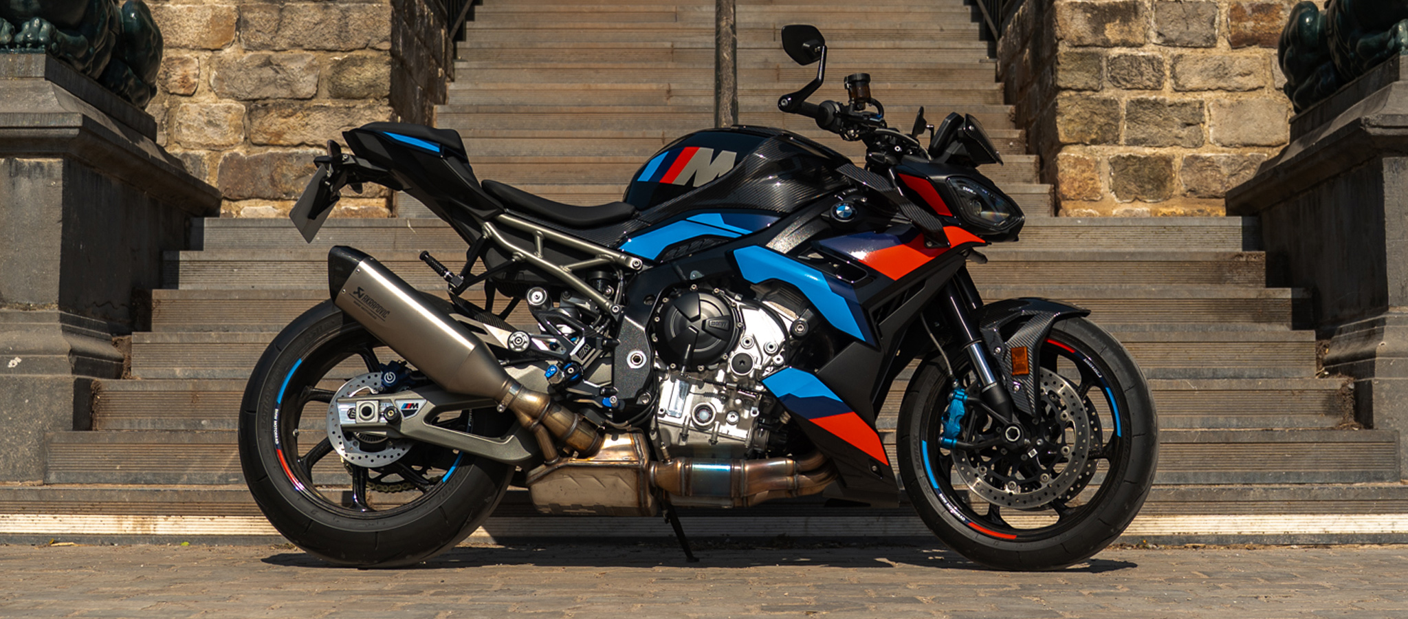 Logo BMW sur réservoir carbone de la BMW M1000R aux couleurs M Sport - Édition Virage Après Virage